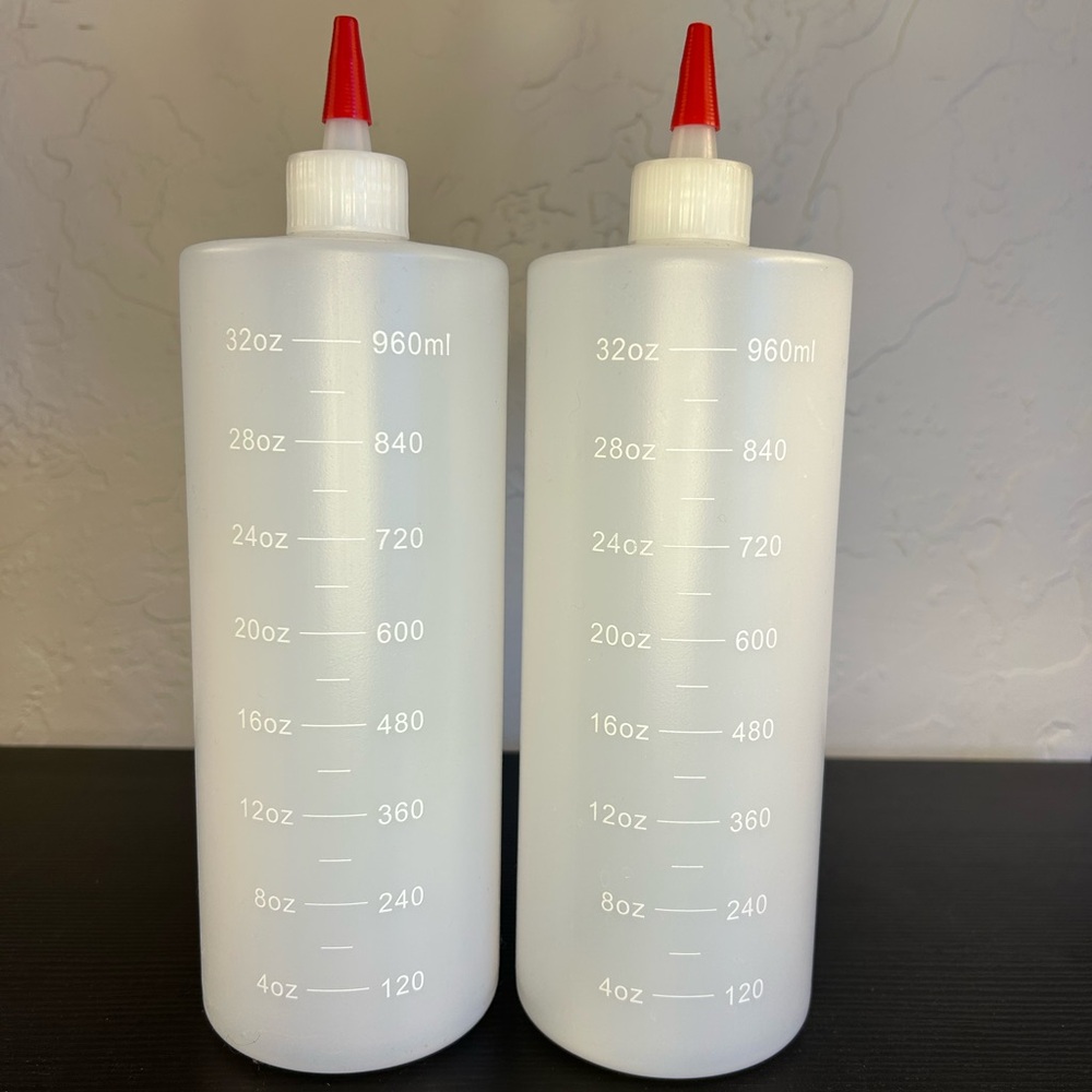 Two Clear Squeeze Bottles with Red Caps